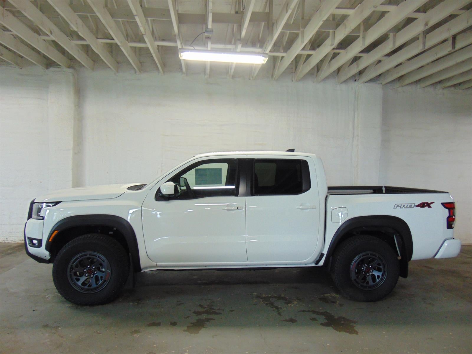 2026 Nissan Frontier CREW CAB 4X4 PRO-4X in Glacier White Qak — front three-quarter view